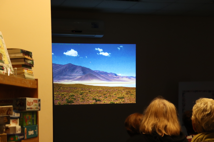 Fotografia przedstawiająca wyświetlone zdjecie z pustyni Atakama w przyciemnionej sali biblioteki